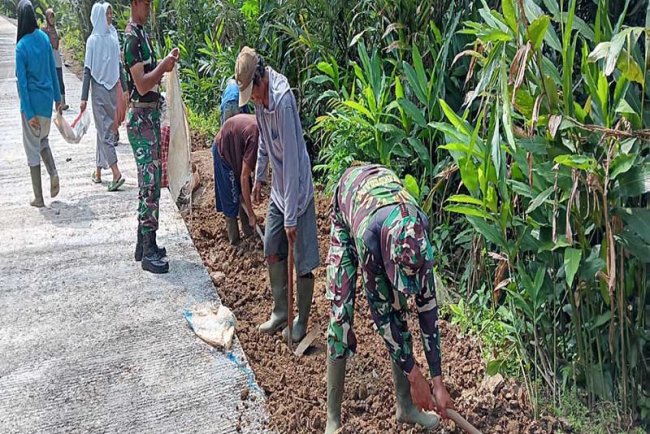 Kerja Sama TNI dan Warga Sijenggung Pengurugan Kiri Kanan Rabat Beton untuk Infrastruktur Desa