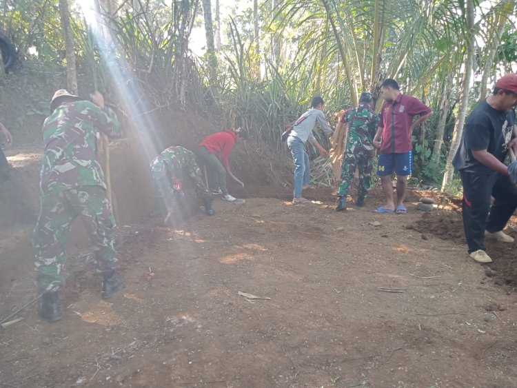 Anggota TNI bersama masyarakat melaksanakan gotong royong