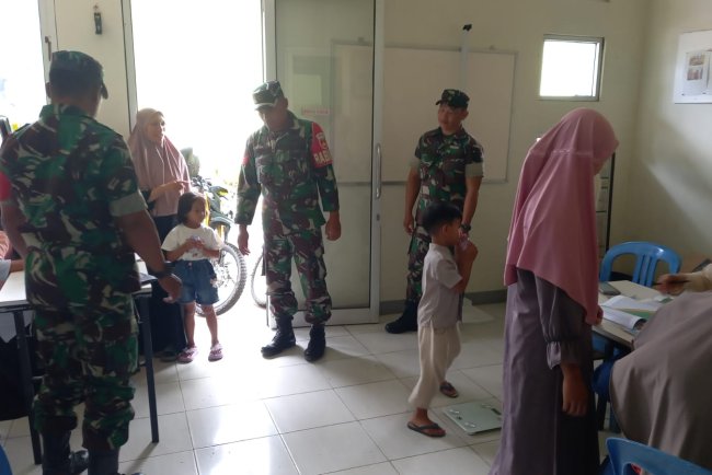 Babinsa Koramil 04 Karangkobar Bantu Bidan Desa Dampingi Giat Posyandu Balita