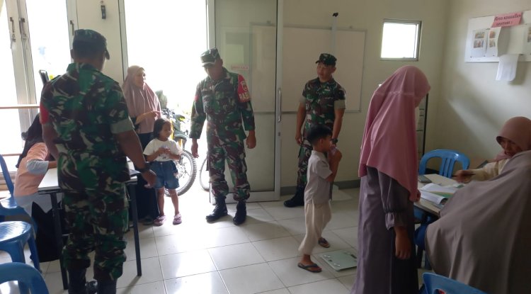 Babinsa Koramil 04 Karangkobar Bantu Bidan Desa Dampingi Giat Posyandu Balita